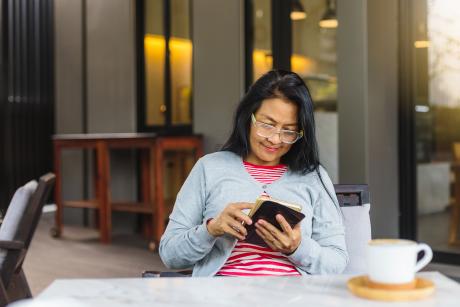 Woman reading Generations on her phone at a coffee shop