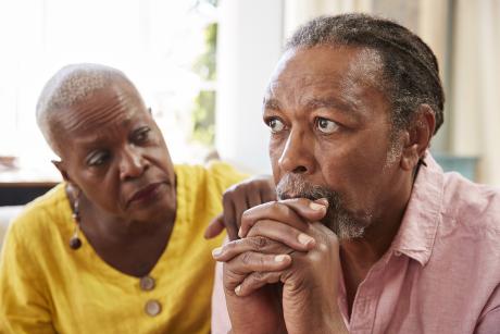 older couple together looking sad. 