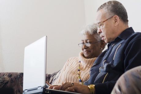 An older couple looking a computer together
