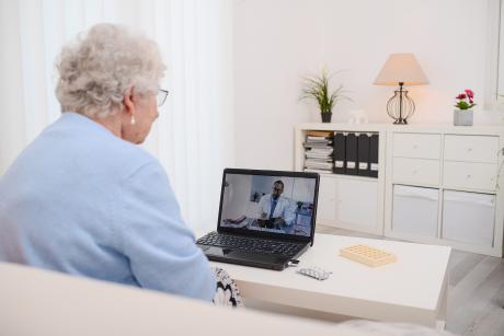 An older woman speaks with a doctor during a telehealth appointment