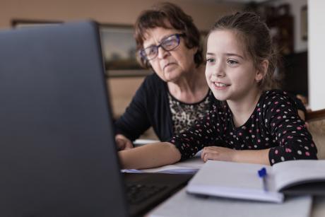 grandmother helping grandchildren with school zoom