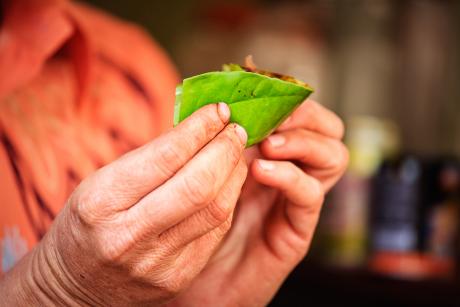 closeup of hands preparing paan