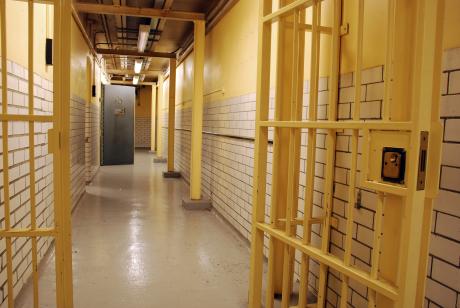 A prison corridor with open cell door and open prison gate