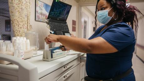 At Advantage Living Center in Roseville, Michigan, Janelle prepares medication for a resident.