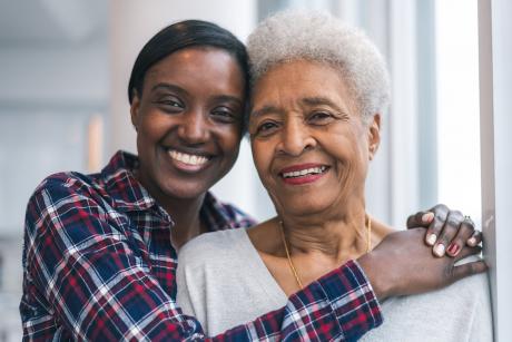 Mother and daughter smiling, embracing