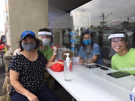Vietnamese older adult and her caregiver at a COVID-19 testing site.