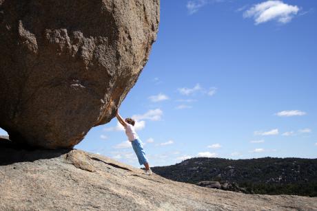 Person holds up boulder