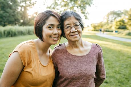Two Southeast asian women, a mother and daughter looking and smiling at the camera