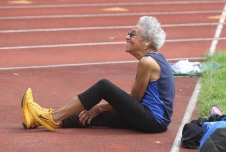 Ida Keeling sitting on a track, smiling