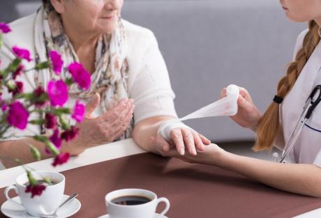 Woman getting wound dressed in nursing home