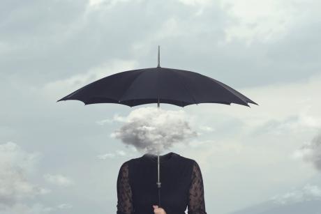 Cloud obscuring woman's head under umbrella