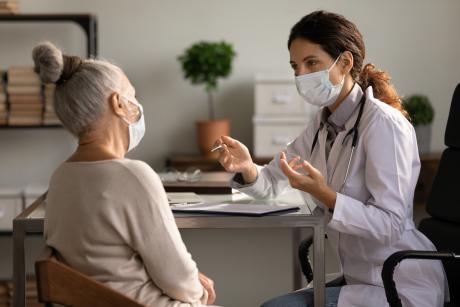 Masked doctor and patient older adult