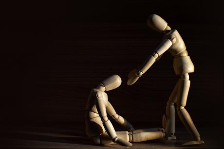 One wooden doll pulls up another