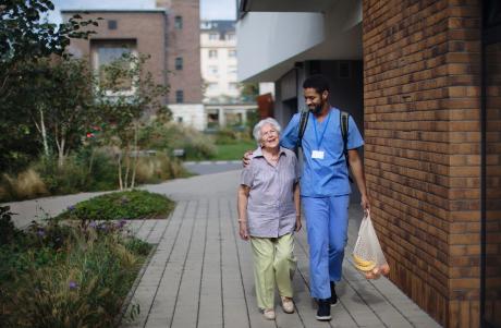 Older woman laughs with caregiver