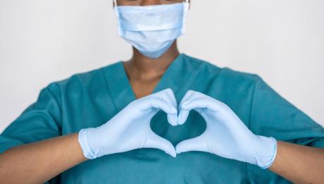 Nurse in mask makes heart sign