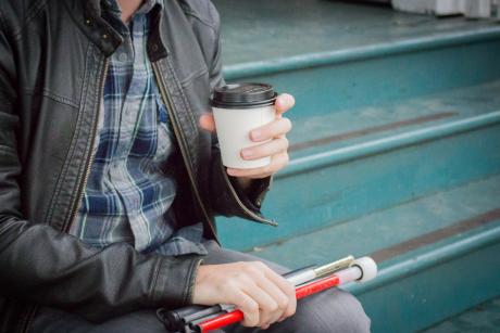 Blind man relaxing with cup of coffee
