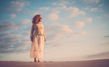 Dreamy shot of an older woman on a beach