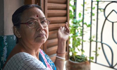 Southeast Asian woman looking out window